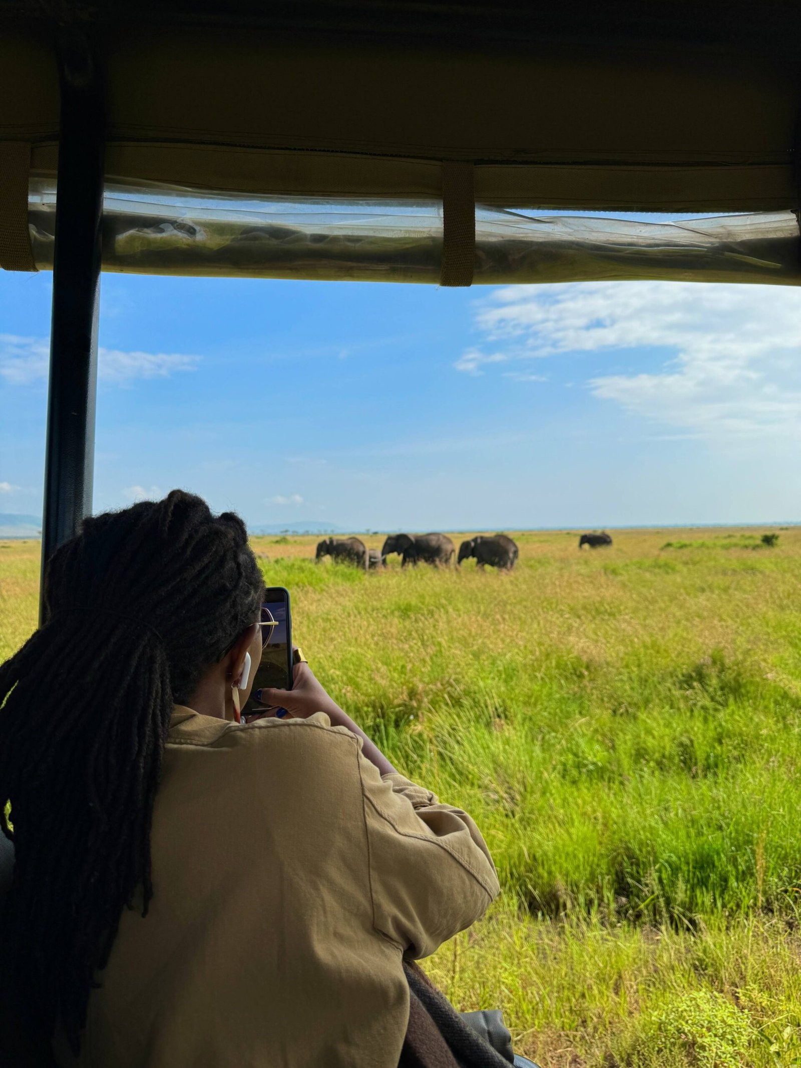 Person on a safari taking a picture of elephants at Maasai Mara