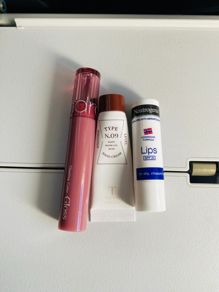 Lipgloss, handcream and lip balm on airport tray table