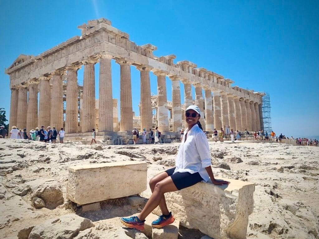 Black woman posing in front of the Acropolis in Athens, Greece on a sunny touristy summer day