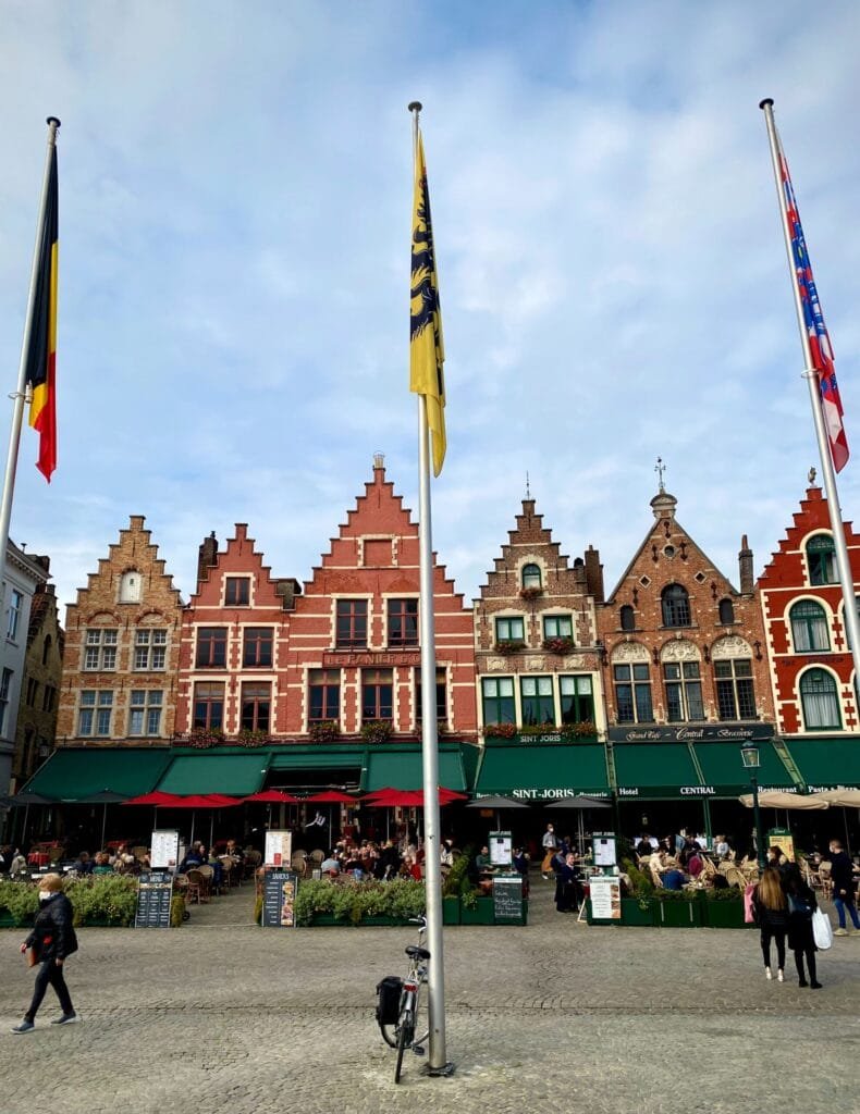 Colorful street with ornate buildings and flags typical of a European city square