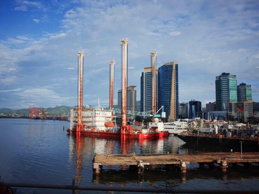 view of industrial construction sight and skyscrapers in port of spain taken from ferry