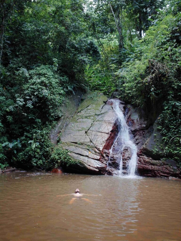 man enjoying a dip in a waterfall on a hot summer day in the caribbean