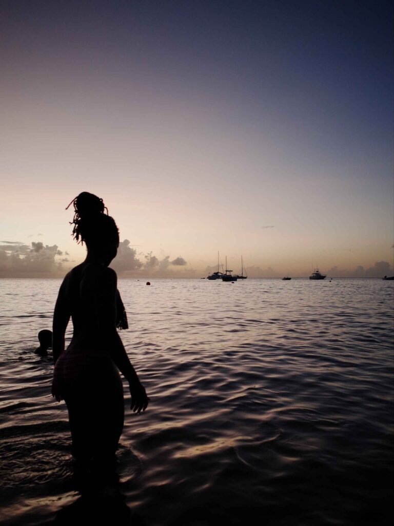woman and child enjoying an evening sunset swim overlooking caribbean horizon
