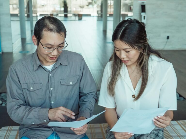 Two people seated side by side reviewing paperwork