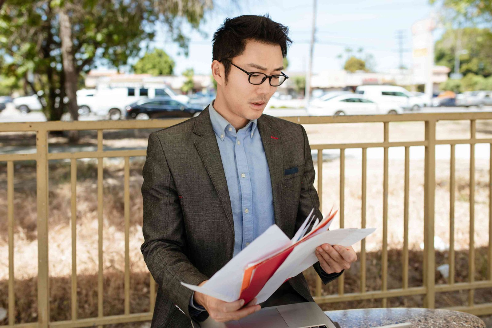 asian-man-in-a-suit-perusing-through-documents-signalling-uncertainty-over-documents-needed-for-uk-visitor-visa