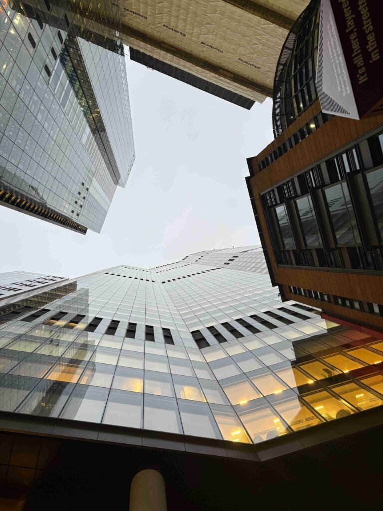 Looking up at 22 Bishopsgate from street level, with surrounding buildings framing the glass skyscraper.