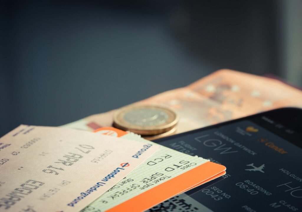 Phone showing travel itinerary with airline tickets and euro coins signalling Schengen visa application process