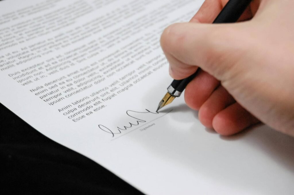 closeup of a hand signing a mock uk visitor visa cover letter