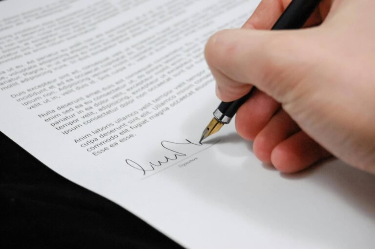 closeup of a hand signing a mock uk visitor visa cover letter